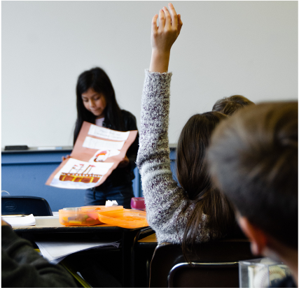 Girl raises her hand in class