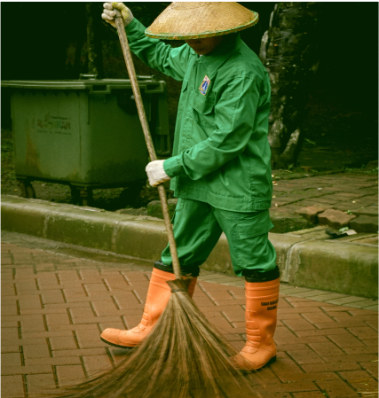 person in green clothes sweeping