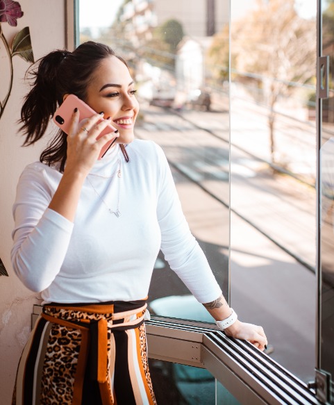 women in white long sleeve shirt on phone